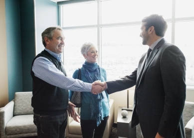 advisor shaking hand with man, older couple in their